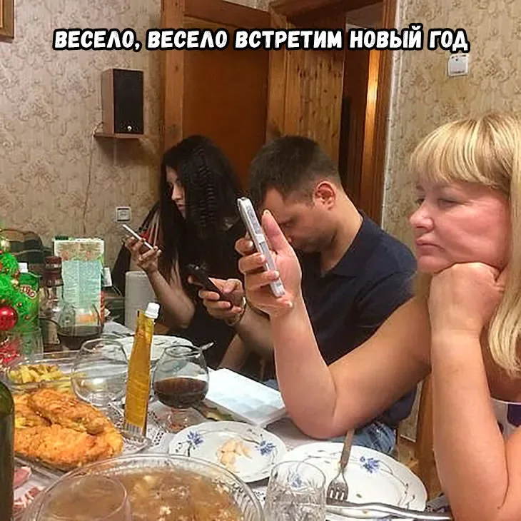 Новогоднее застолье: гости смотрят в телефоны
